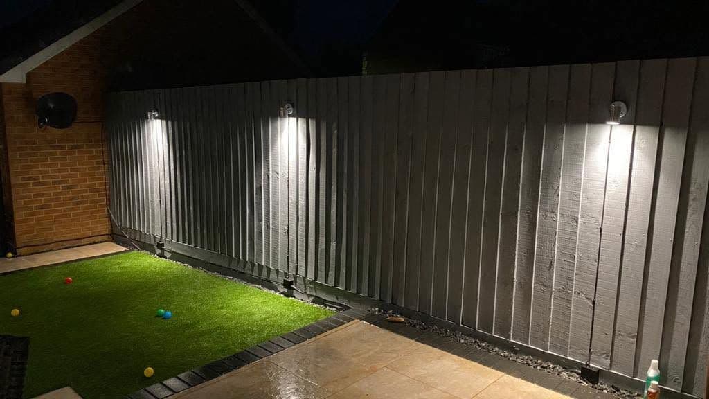 Garden fence wall lights lighting up a patio at night